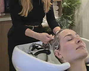 Aplicação de tratamento capilar durante lavagem no salão Nathalie Charlot em Almancil